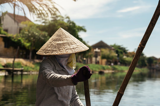 Unrecognizable vietnamese woman on a boat rowing.