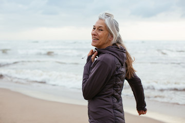 Fototapeta premium Active senior woman doing sport on the beach.