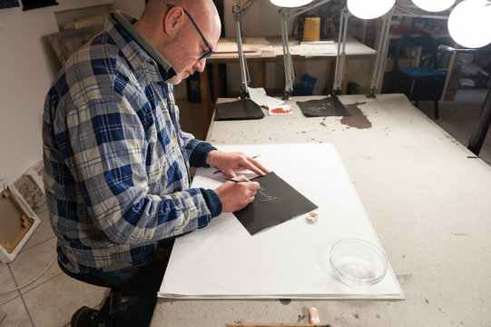 A Master Calligrapher writing elegant cursive lettering with a nib mounted on a oblique holder