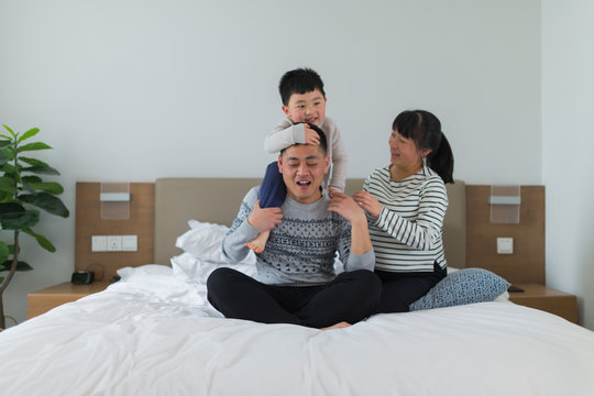 happy asian family of four in home