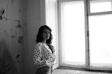 Young woman in a blouse in an abandoned room