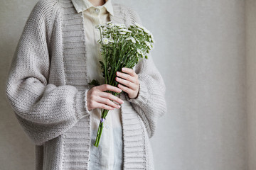 photo of young woman holding white flowers with green stem in her hands - 268192294