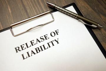 Clipboard with release of liability and pen on desk