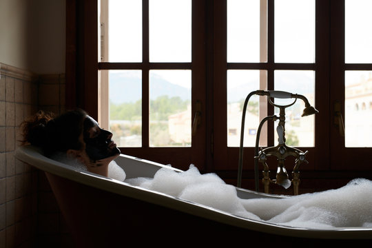 Woman having relaxing bath with foam