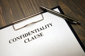 Clipboard with confidentiality clause and pen on desk