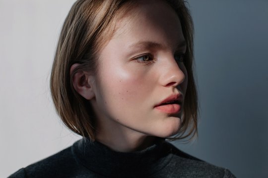 Portrait of pretty blond female posing in contrast daylight