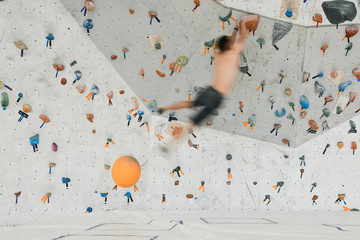 Anonymous man jumping among rocks on wall