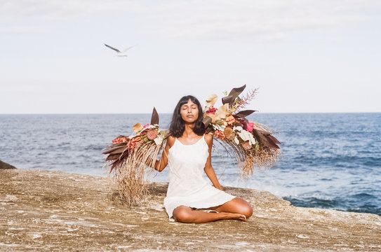 Beautiful Woman with flowers at the beach
