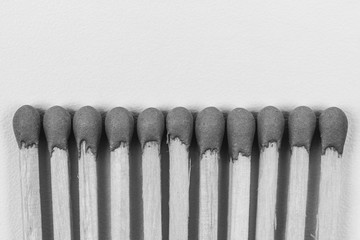 wooden matches on grey background with copy space closeup, top view black and white photo