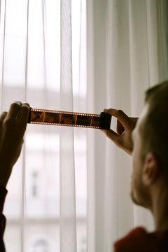 Young man looking at the film roll