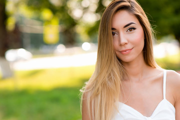 Beautiful gentle woman white dress happy smiling. Free space for text. Summer park in fresh air....