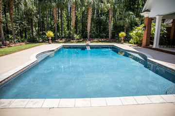 Large Blue Swimming Pool Outdoors  with pool Cleaner running and a Diving Board