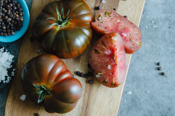 Sweet Marmande tomato cut on wooden board. Top view.