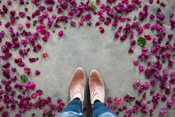 woman standing among bougainvillea petals with copy space