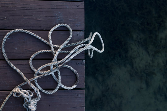 A Rope On The Dock With Clear Water Below It