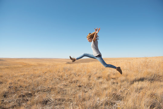 Woman Leaping In Field