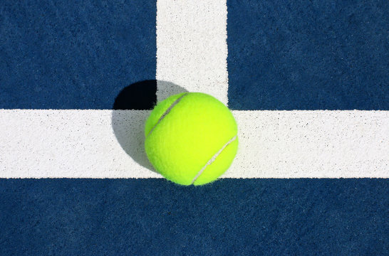 Tennis Ball on Service Line of Blue Hard Court