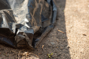 Black plastic garbage bag on the ground