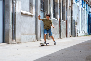 Front view of cheerful skater boy riding on the city in a sunny day © Rafa Fernandez
