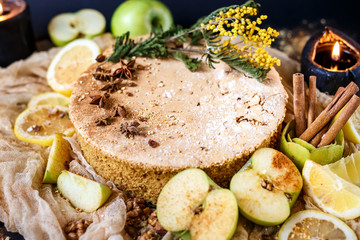 Biscuit apple pie with cinnamon, citron, oriental spices and sugar powder on dark background