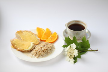 breakfast consists of oatmeal cheese sandwiches and orange slices and a cup of coffee