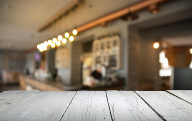 image of wooden table in front of abstract blurred background of resturant lights