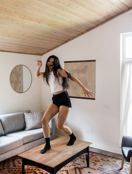 young woman dancing on coffee table