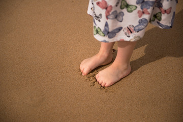Fototapeta na wymiar Children's feet in the sand