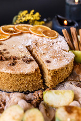 Fototapeta na wymiar Biscuit apple pie with cinnamon, citron, oriental spices and sugar powder on dark background