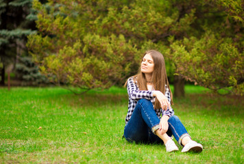Fototapeta premium Attractive young woman enjoying her time outside in park with sunset in background.