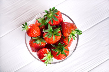 bowl of fresh strawberries on a white wooden table