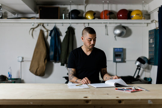 young male in studio workshop designing at table