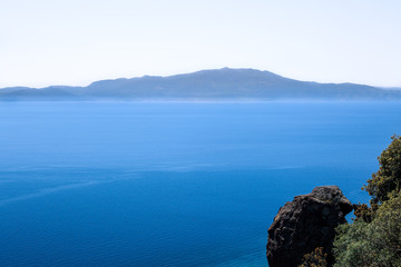 Fototapeta na wymiar View from Assos to Lesbos (Mitilini or Midilli) Island on Aegean Sea. Aegean Sea at summer. View from Assos to Lesbos Island. Empty Panoramic Rock at Assos. Turkey