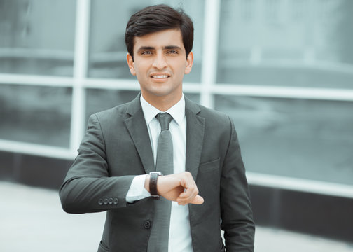 A young man checks his watch.