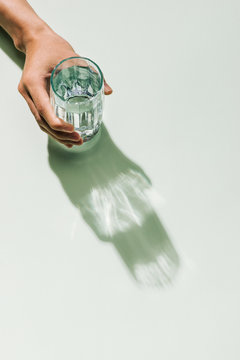 Man's hand holding glass of water