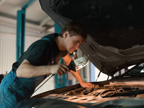Technician exploring engine with lamp