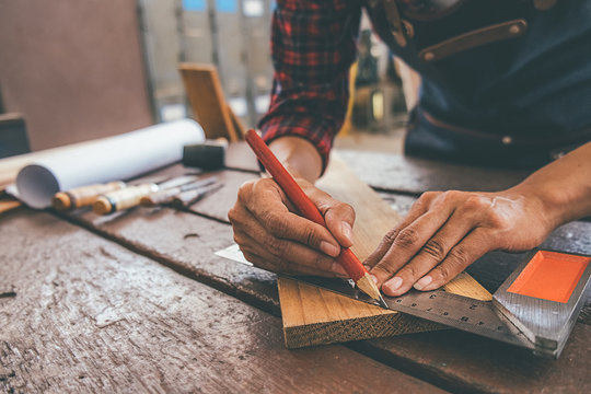 Carpenter working with equipment on wooden table in carpentry shop. woman works in a carpentry shop.