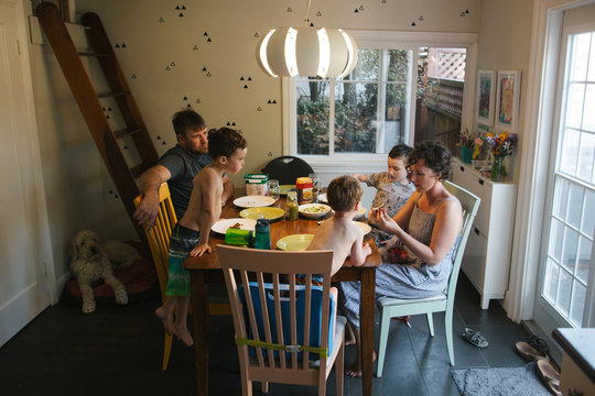 Family of five eating dinner together at home