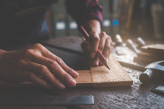 Carpenter working with equipment on wooden table in carpentry shop. woman works in a carpentry shop.