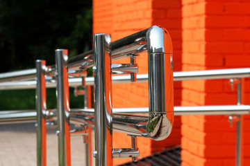 Metal steel handrail with a exit for invalid near the premises. Brick wall painted with orange paint