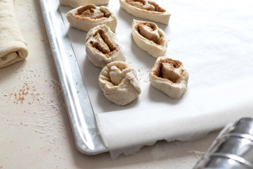 Baking lies on the tray. The process of cooking buns. On the table is flour, dough, fixtures