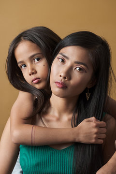 Portrait of mother and daughter embracing indoors