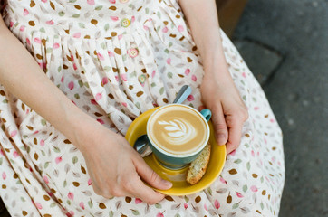 Woman holding cup of cappuccino