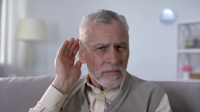 Confused pensioner trying to hear conversation, problem of deafness in old age