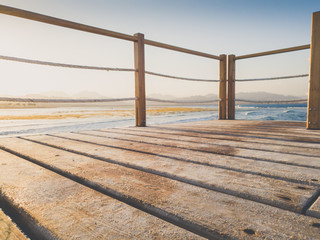 Closeup toned photo of wooden bridge in the sea. Perfect for inserting your image or placing product. Place for text. Copy space