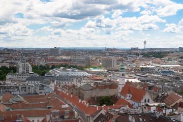 Fototapeta na wymiar Wien, Austria. May, 2019. Panorama of the city from the observation tower of St. Stephen’s Cathedral. Roofs of houses. In the distance, the Alpine Mountains. Sky view.