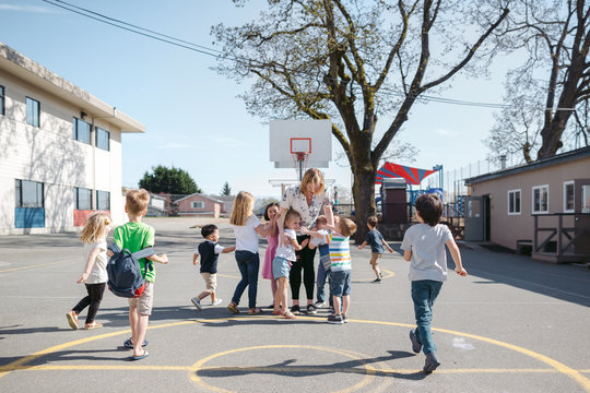 Woman with kids on outside on school playground