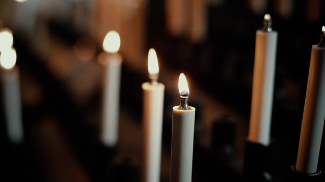 Close up footage of a burning candle inside a church