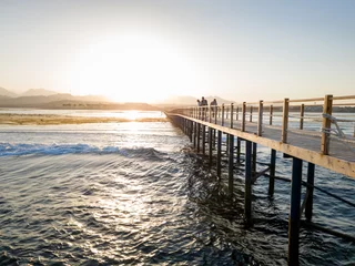 Crédence de cuisine Paysages Beautiful landscape of long wooden pier and calm sea waves against sunset and mountains  © Kyrylo Ryzhov