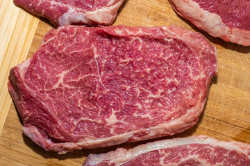 Raw steaks on wooden background. fresh meat. Top view